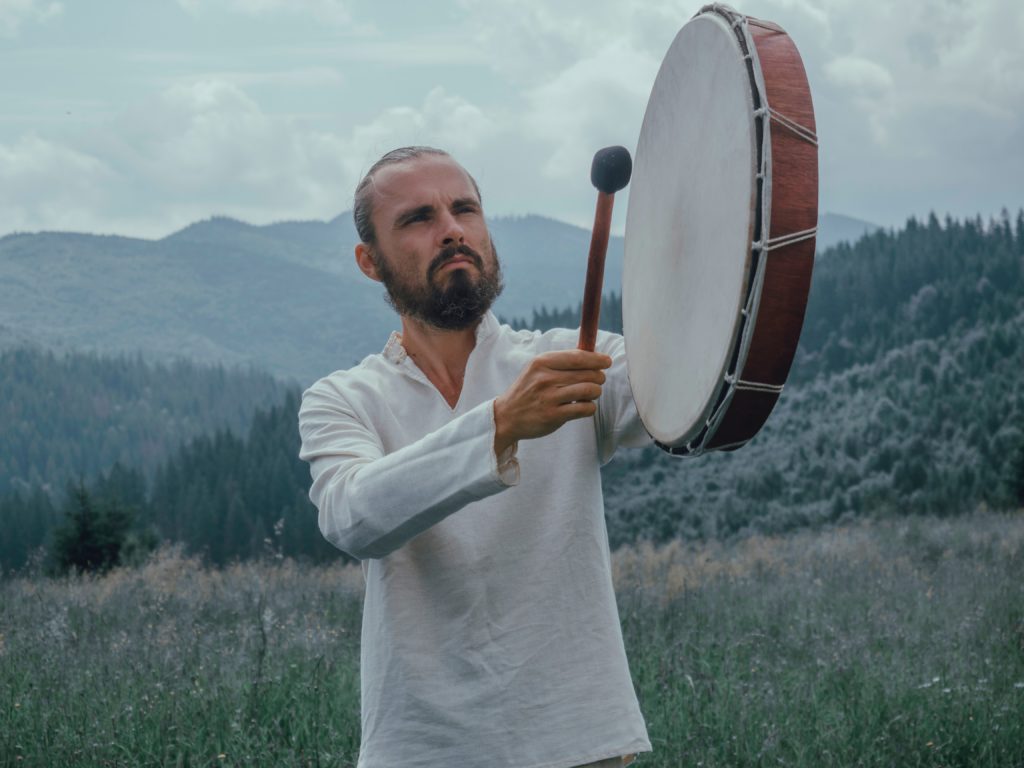 man playing shaman drum