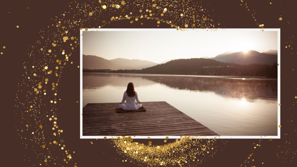 Woman meditating on a dock by a peaceful lake